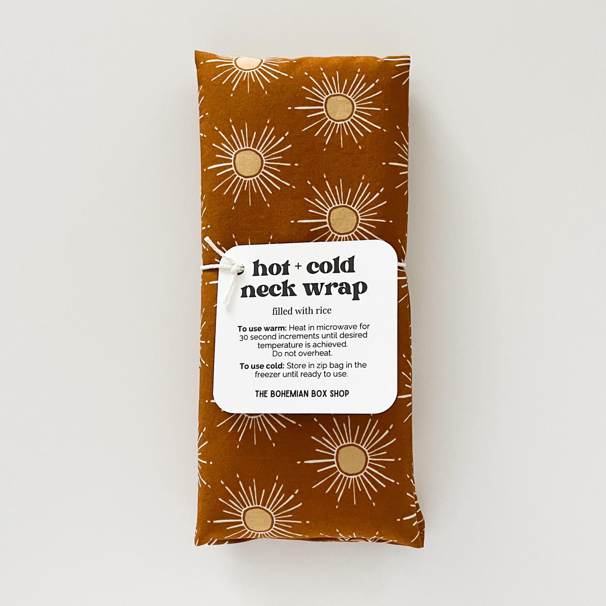 dark orange neck wrap with sun pattern and label on a white background