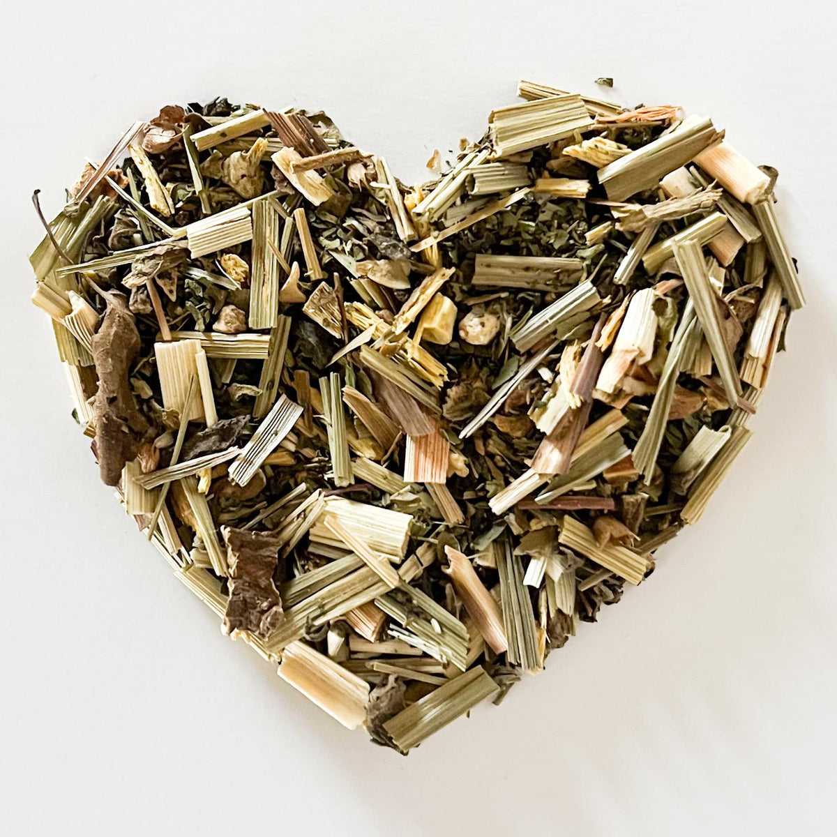 Heart-shaped arrangement of dried herbs on a white background
