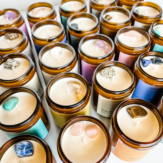 assorted 8oz crystal soy candles for energy cleansing, intentions and protection. They are poured in an amber jar with cotton wick with colorful boho labels. 