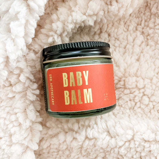 Urb Apothecary Baby Balm. 2oz jar with orange label and black lid.