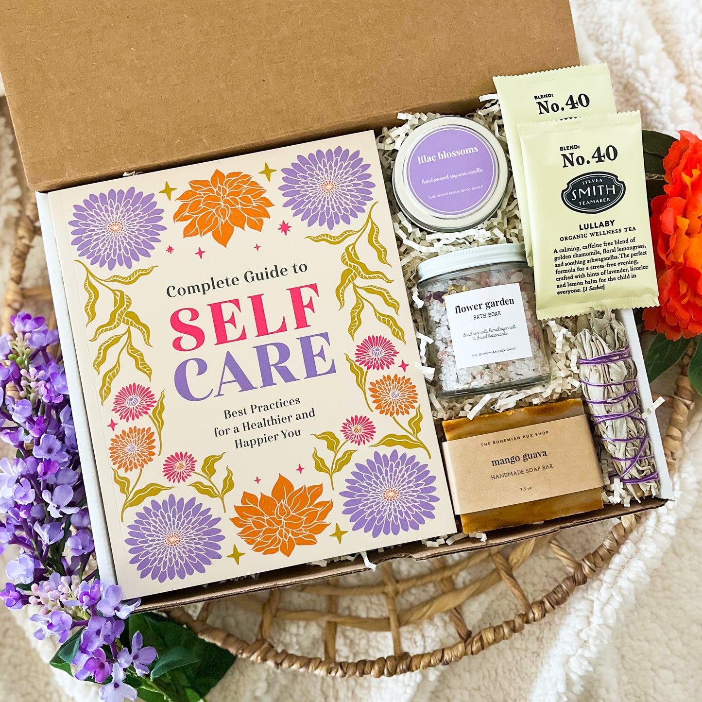 Self-care gift set for women. Includes a complete guy to self-care book, lilac soy candle, flower garden bath soak mango guava soap, tea packets, and mini sage bundle. ￼