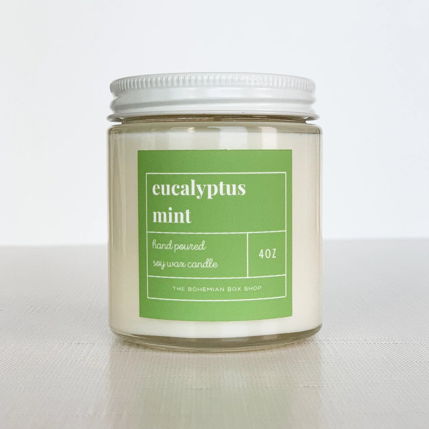 4 ounce eucalyptus mint soy candle with green label, clear jar, and white lid