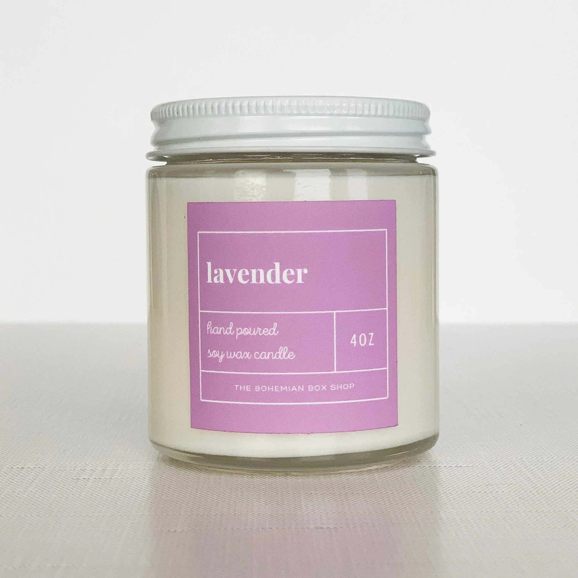 4 ounce lavender soy candle with purple label, clear jar, and white lid.￼