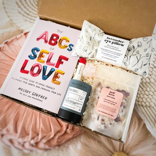 Self-love gift set for women. Contains ABC’s of self-love book, lavender eye pillow, strawberry lip balm, rose quartz crystal, lemon cream tea, and self-love bath salt packet with affirmation. ￼