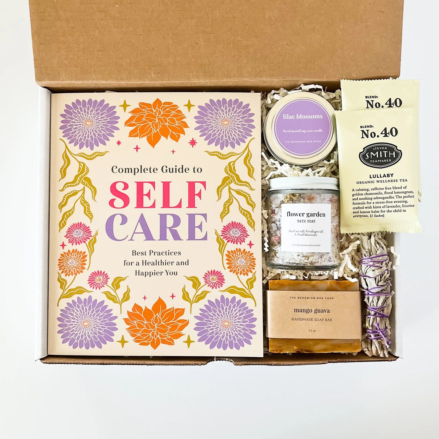 Self-care gift set for women. Includes a complete guy to self-care book, lilac soy candle, flower garden bath soak mango guava soap, tea packets, and mini sage bundle. 