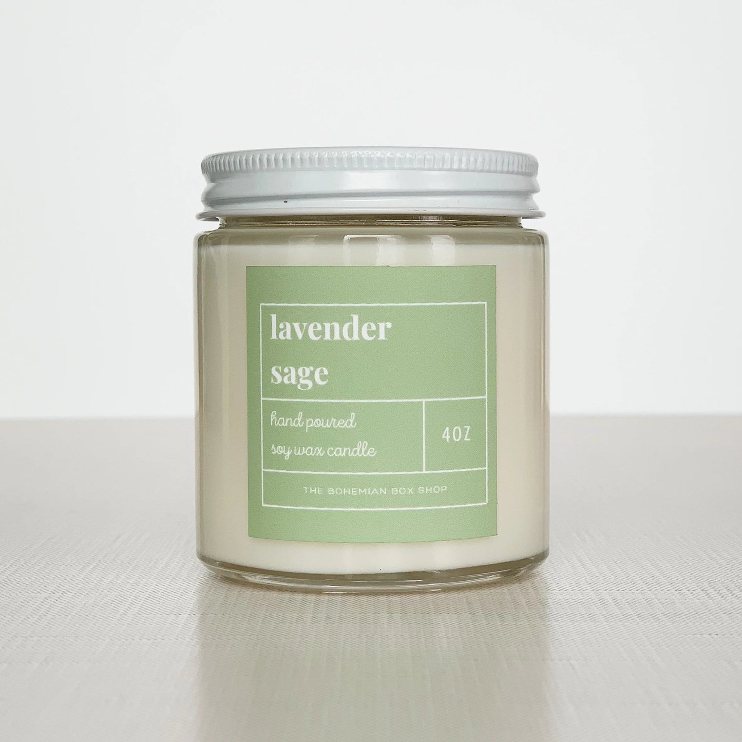 4 ounce lavender sage soy candle with  green label, clear jar, and white lid.