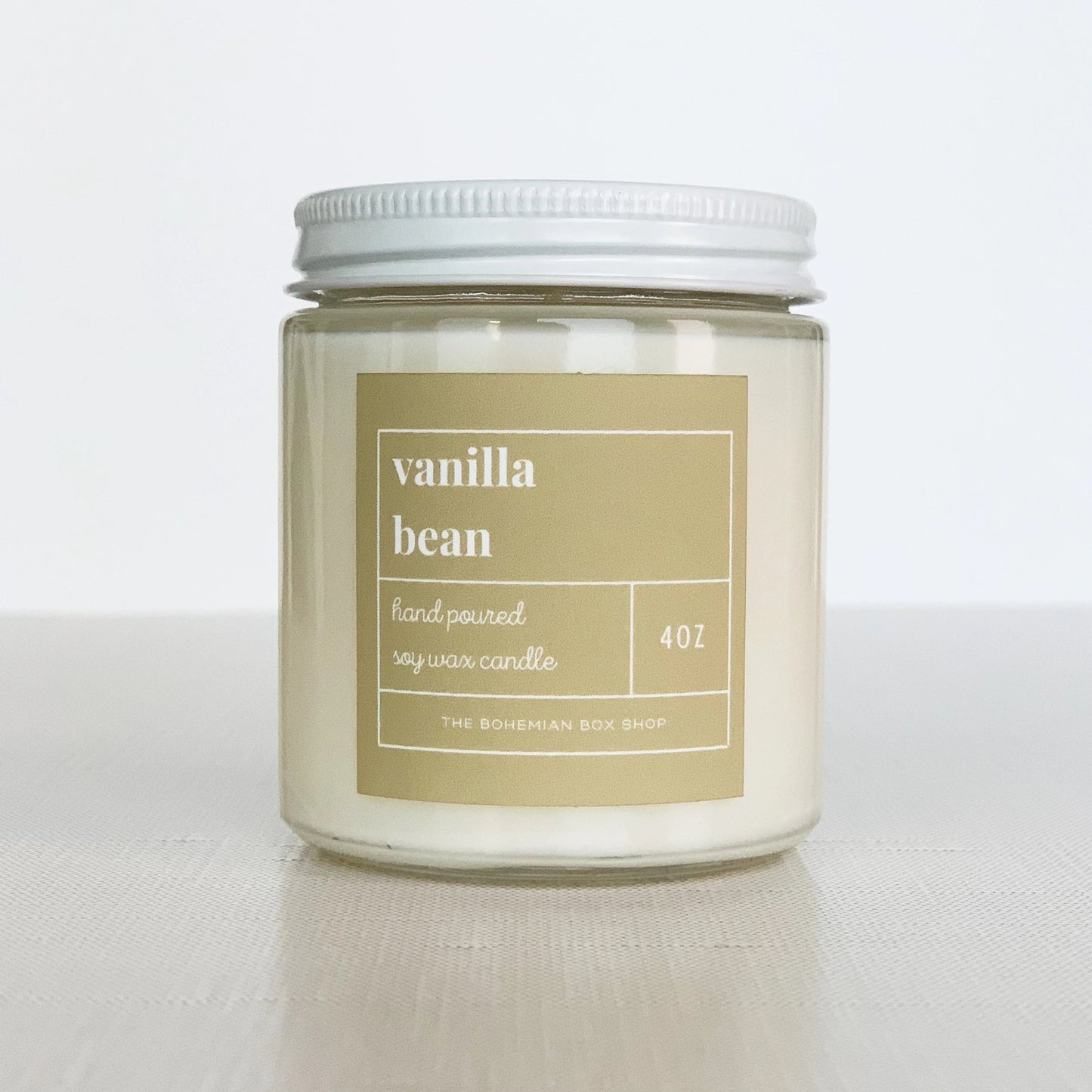 4 ounce vanilla bean soy candle with cream label, clear jar, and white lid.