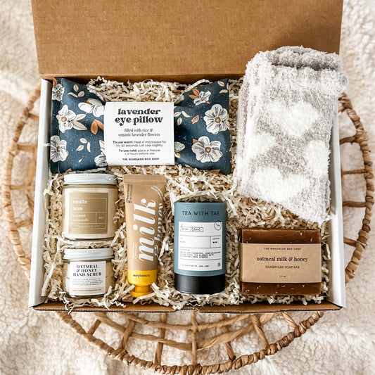 Boho Spa Gift Box for Women. Includes floral lavender eye pillow, vanilla bean soy candle, oatmeal and honey hand scrub, hand cream, lemon creme tea, oatmeal and honey soap and grey heart socks for women. 