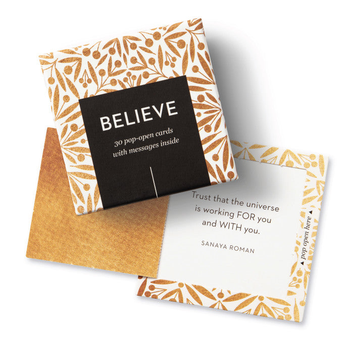 Packaging of 'Believe' cards with floral design and quote by Sanaya Roman.