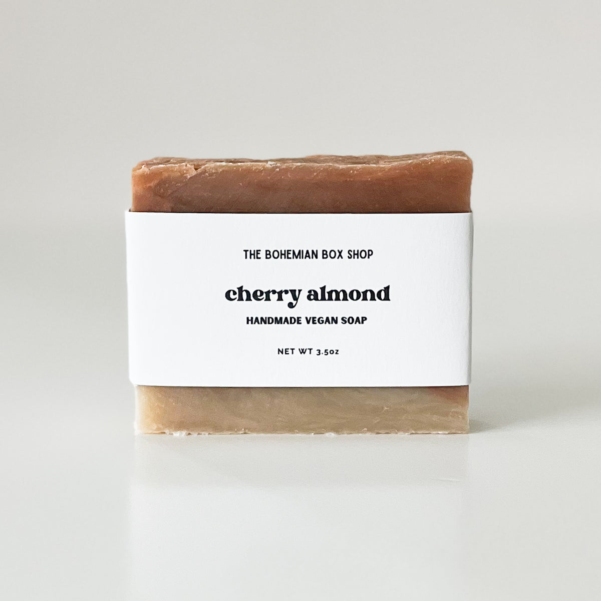 A bar of handmade vegan soap with 'The Bohemian Box Shop Cherry Almond' label on a white background.