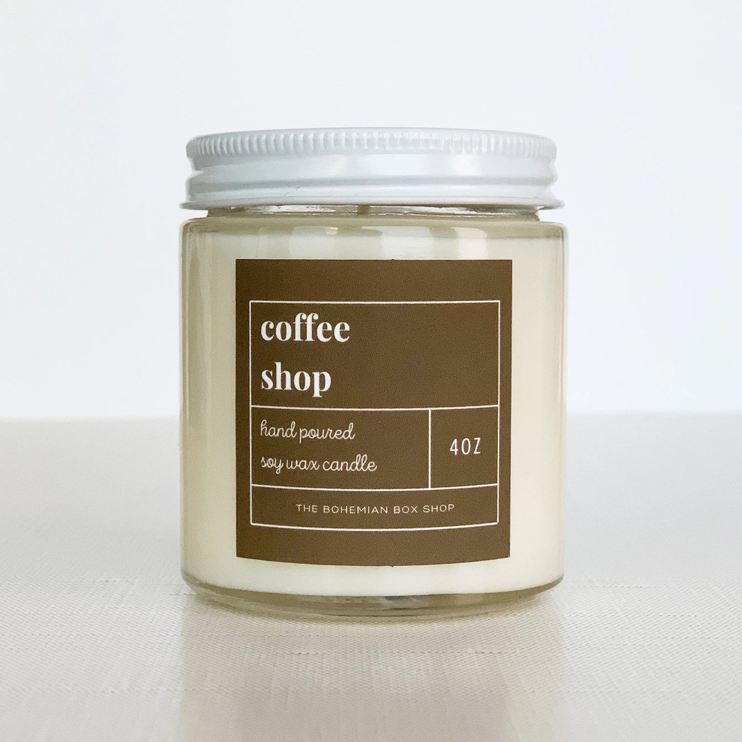 4 coffee shop soy candle with brown label, clear jar, and white lid.