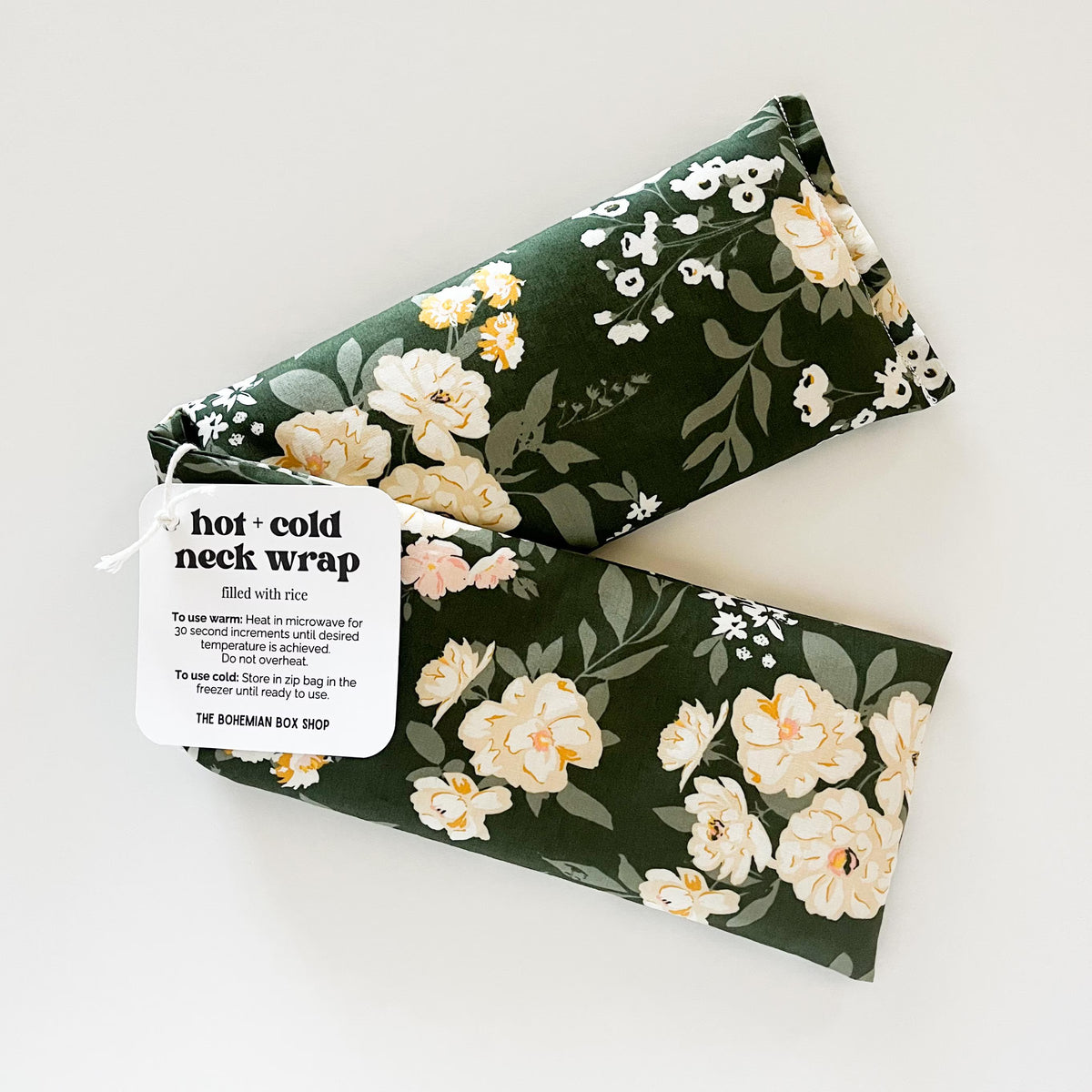 green Floral patterned hot and cold neck wrap with a label on a white background