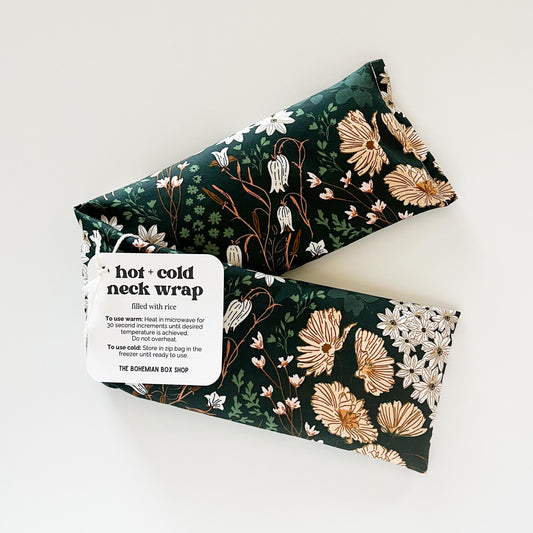 Dark green floral patterned hot and cold neck wrap with label on a white background