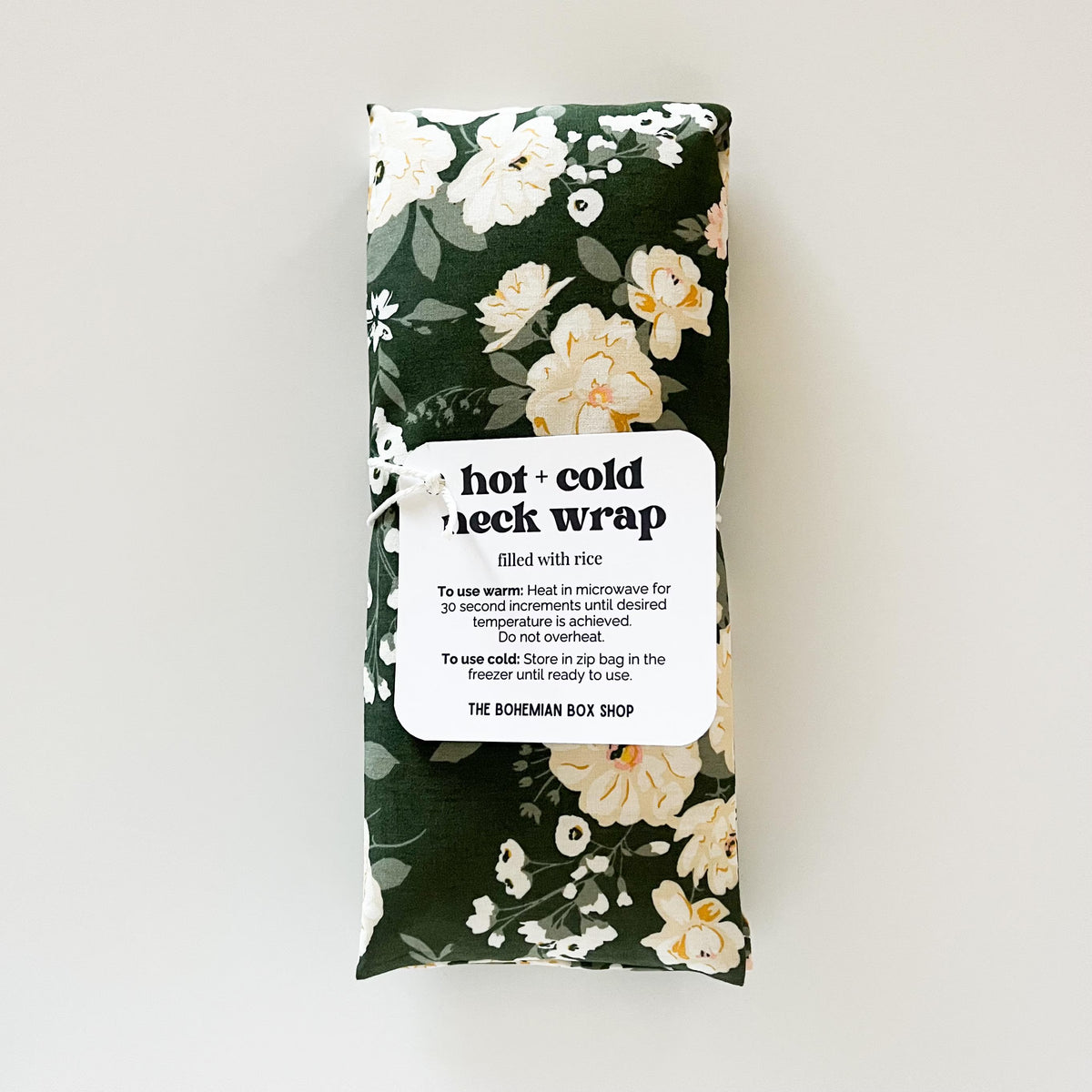 Floral-patterned hot and cold neck wrap with a label on a white background