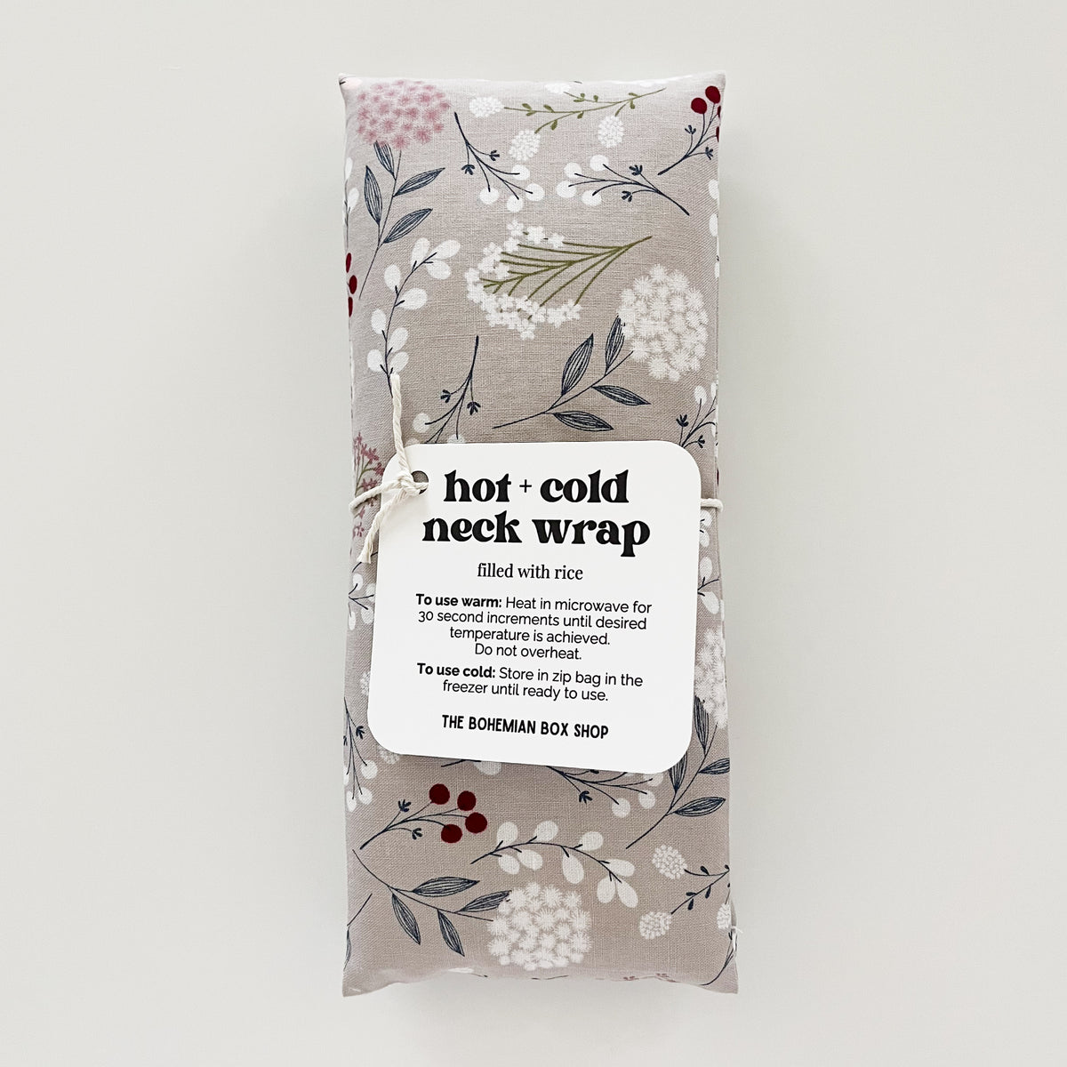 Hot and cold neck wrap in a grey floral fabric pattern filled with rice and made by The Bohemian Box Shop