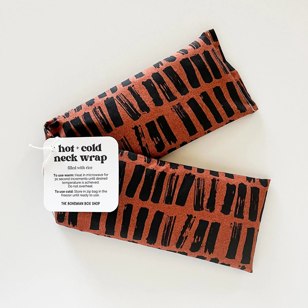 a hot and cold neck wrap with a black and brown pattern on a white background