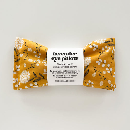 Yellow floral lavender eye pillow with a label on a white background
