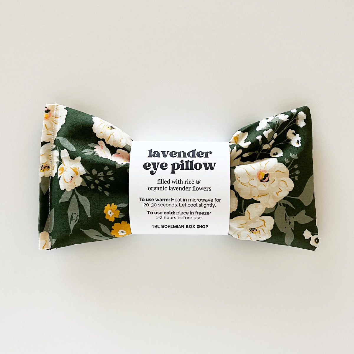 Lavender eye pillow with green background and yellow and white flowers on a white background