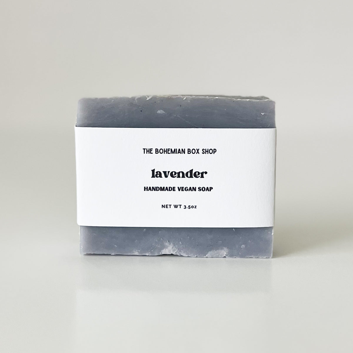 A bar of handmade lavender soap with a label that reads 'Lavender Handmade Soap' and made by The Bohemian Box Shop
