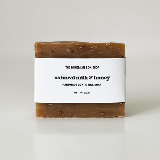 a bar of oatmeal milk and honey soap wrapped in a white label made by the Bohemian Box Shop