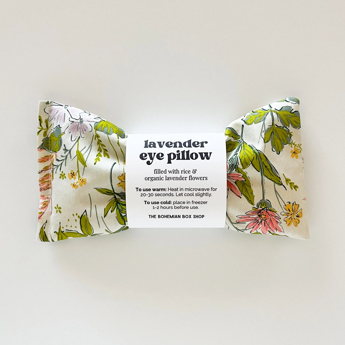 Lavender eye pillow with floral design and packaging label on a white background