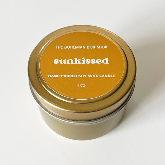 Scented candle in a tin with 'sunkissed' label on a white background