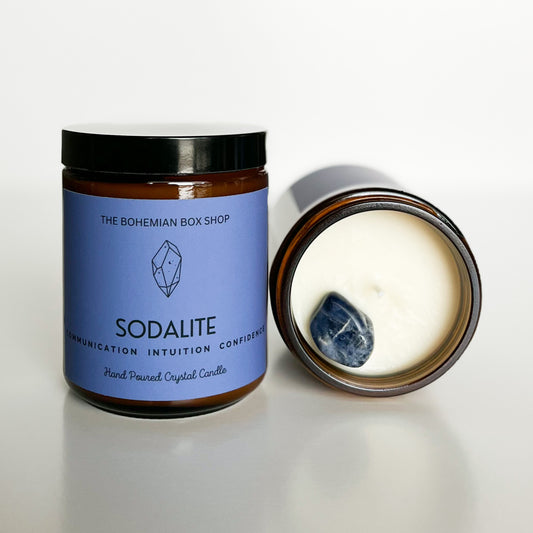 sodalite crystal candle with a blue label next to an open candle showing the white wax with a sodalite on top