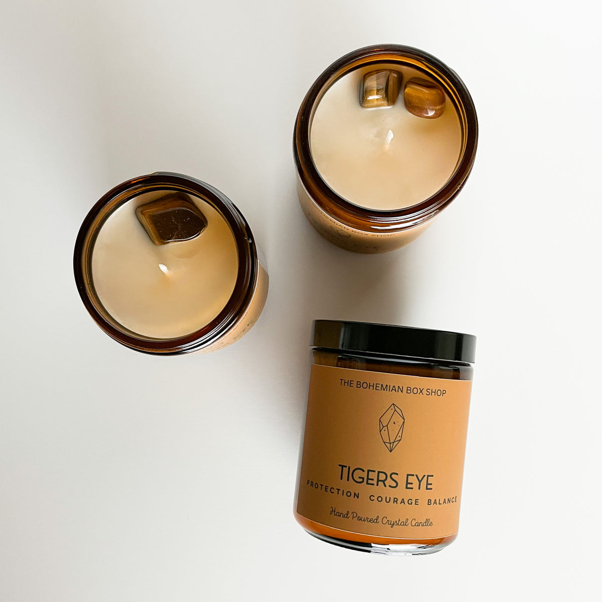 three tigers eye soy candles laid out on a white background